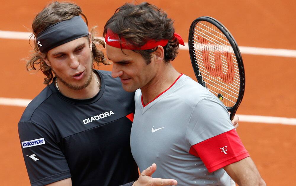 Switzerland's Roger Federer, right, is congratulated by Slovakia's Lukas Lacko after their first round match of the French Open tennis tournament at the Roland Garros stadium, in Paris.