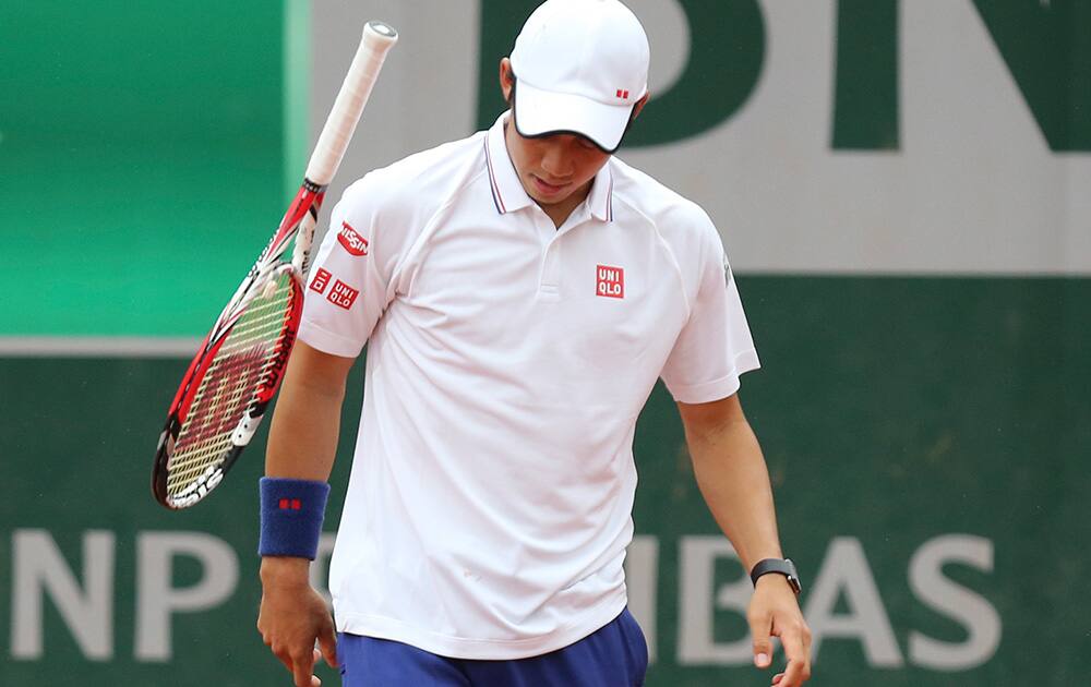 Japan's Kei Nishikori throws his racket after missing a return during the first round match of the French Open tennis tournament against Slovakia's Martin Klizan at the Roland Garros stadium, in Paris, France.
