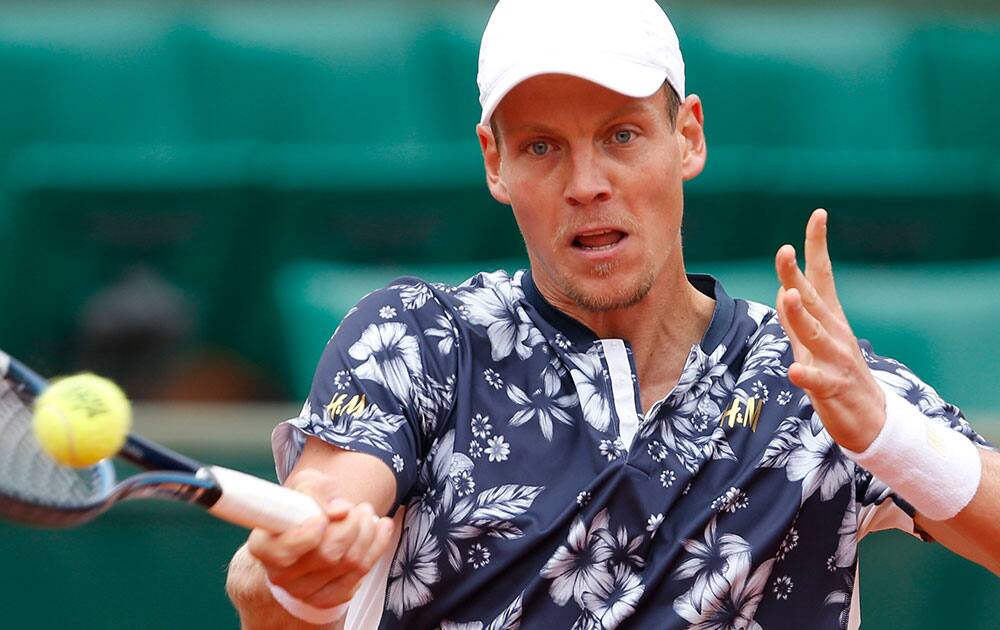 Tomas Berdych of the Czech Republic returns the ball to John Isner of the U.S, during their fourth round match of the French Open tennis tournament at the Roland Garros stadium, in Paris, France.