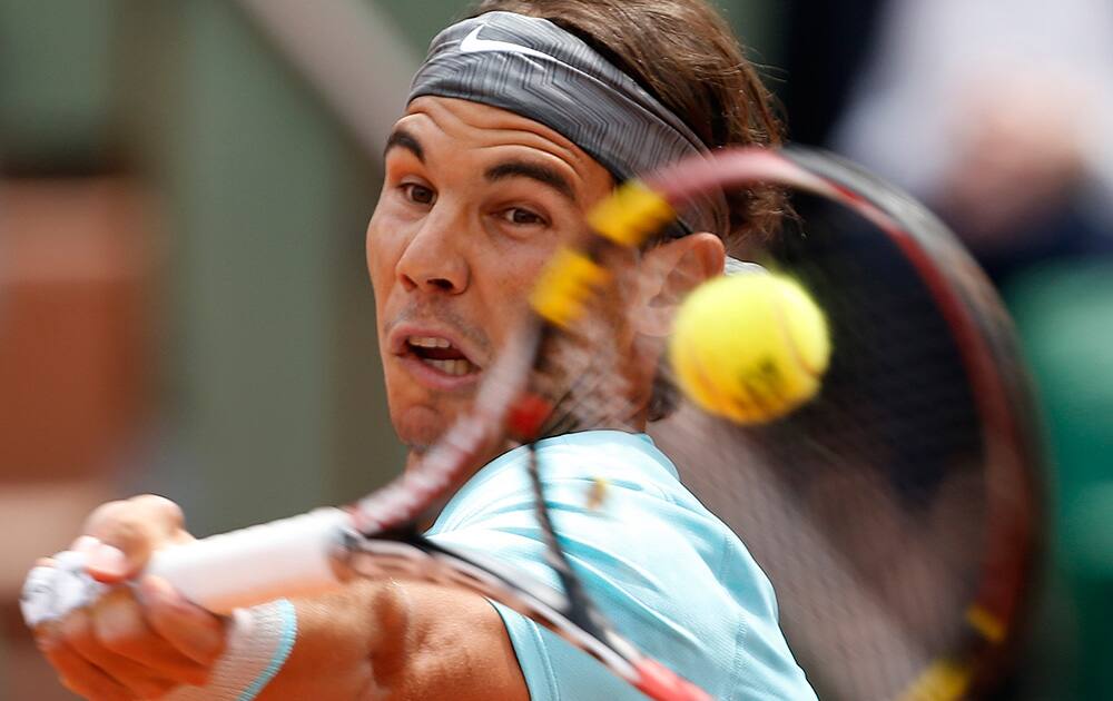 Spain's Rafael Nadal returns the ball to Serbia's Dusan Lajovic during their fourth round match of the French Open tennis tournament at the Roland Garros stadium, in Paris, France.