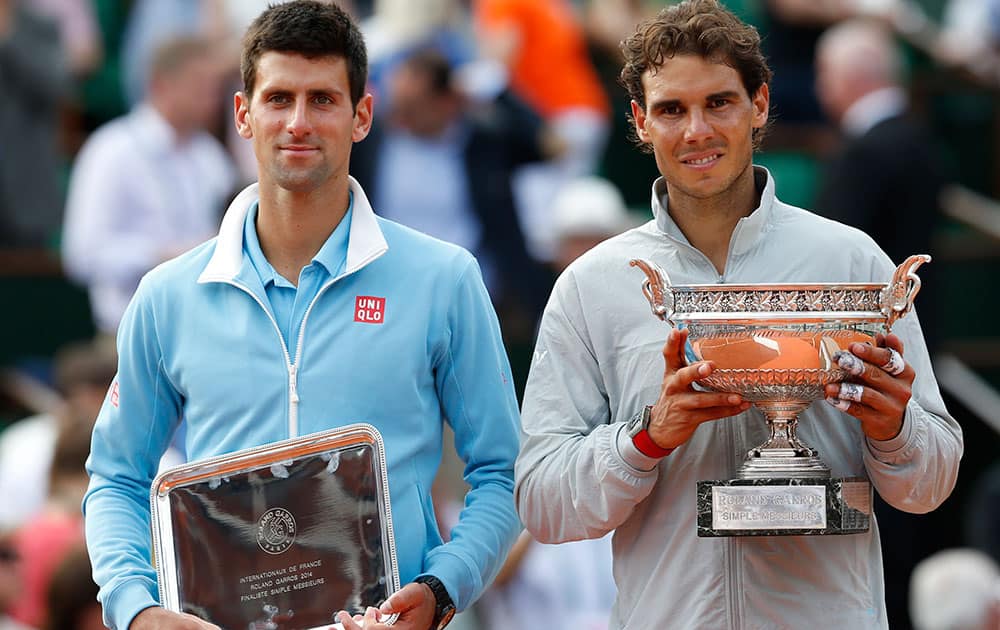 Spain's Rafael Nadal, right, holds the trophy after winning the final of the French Open tennis tournament against Serbia's Novak Djokovic, left, at the Roland Garros stadium, in Paris.