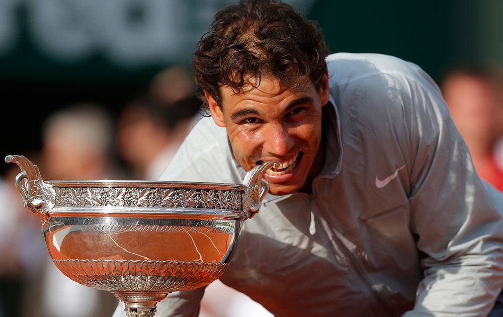 Spain's Rafael Nadal bites the trophy after winning the final of the French Open tennis tournament against Serbia's Novak Djokovic at the Roland Garros stadium, in Paris.