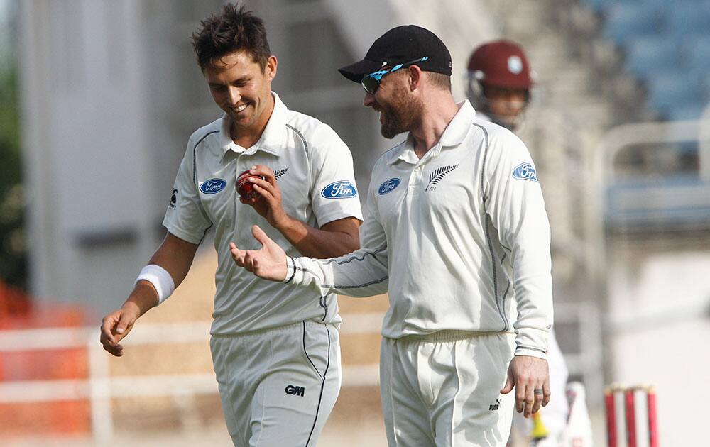 New Zealand's bowler Trent Boult, left, talk with captain Brendon McCullum during the second day of their first cricket Test match against West Indies in Kingston, Jamaica.