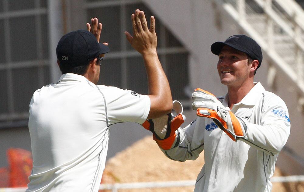 New Zealand's wicket keeper BJ Watling, right, celebrates with teammate Ross Taylor after taking the wicket of West Indies batsman Chris Gayle, who was caught behind for a 10 runs during the second innings on the fourth day of their first cricket Test match in Kingston, Jamaica.