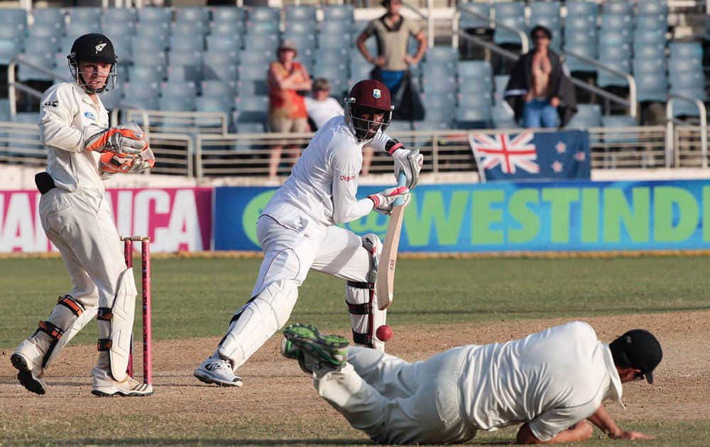 New Zealand's Ross Taylor, on ground, dives in an attempt to catch West Indies batsman Shane Shillingford, center, as New Zealand's wicket keeper BJ Watling, left, look on during the second innings on the fourth day of their first cricket Test match in Kingston, Jamaica.