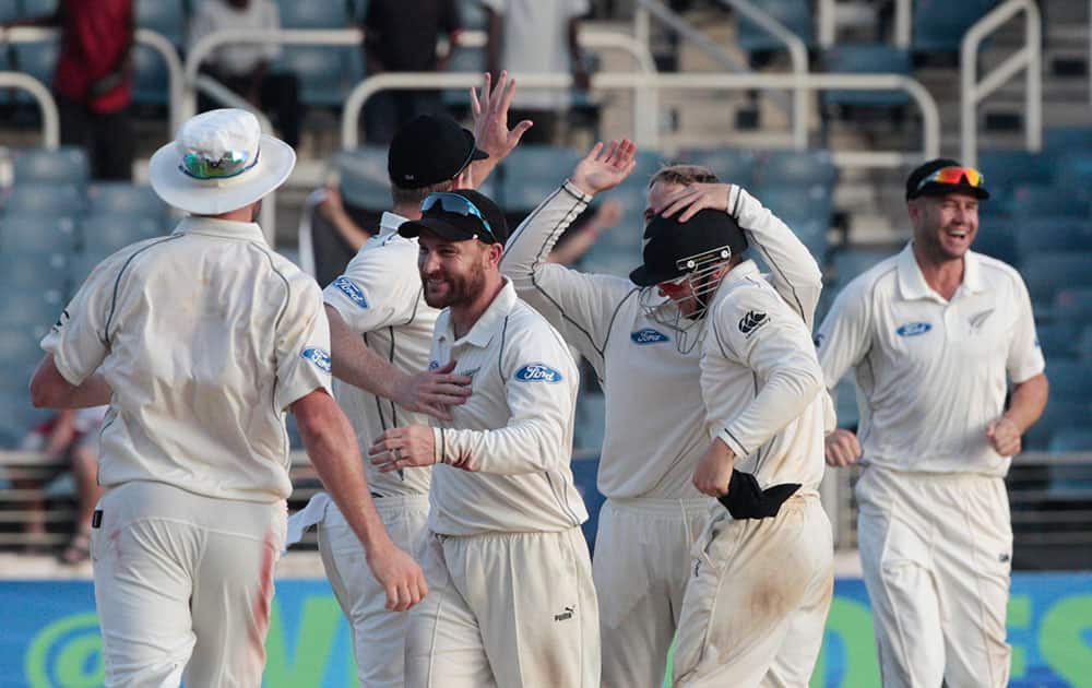New Zealand's cricket player celebrate on the pitch at the end of their first cricket Test match against West Indies in Kingston, Jamaica.