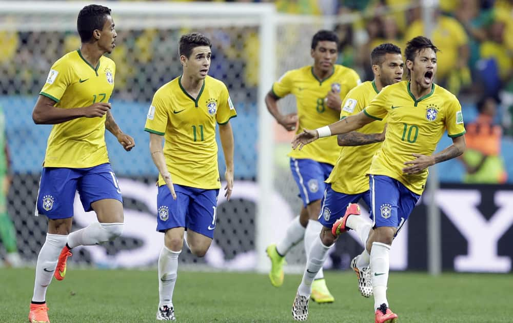 Brazil's Neymar celebrates with teammates after scoring during the group A World Cup soccer match between Brazil and Croatia, the opening game of the tournament, in the Itaquerao Stadium in Sao Paulo, Brazil.