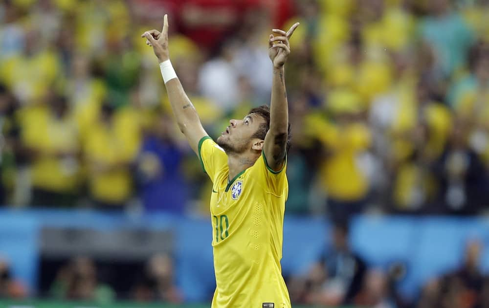 Brazil's Neymar celebrates after scoring during the group A World Cup soccer match between Brazil and Croatia, the opening game of the tournament, in the Itaquerao Stadium in Sao Paulo, Brazil.