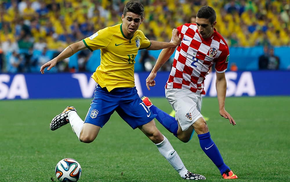 Brazil's Oscar, left, and Croatia's Sime Vrsaljko battle for the ball during the group A World Cup soccer match between Brazil and Croatia, the opening game of the tournament, in the Itaquerao Stadium in Sao Paulo, Brazil.