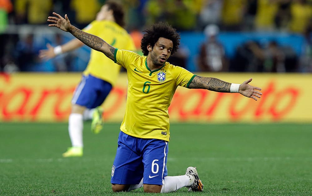 Brazil's Marcelo celebrates after Oscar scored the 3rd goal during the group A World Cup soccer match between Brazil and Croatia, the opening game of the tournament, in the Itaquerao Stadium in Sao Paulo, Brazil