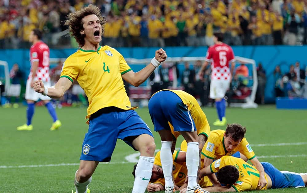 Brazil's David Luiz (4) celebrates teammate Oscar's (11) goal during the group A World Cup soccer match between Brazil and Croatia, the opening game of the tournament, in the Itaquerao Stadium in Sao Paulo, Brazil.