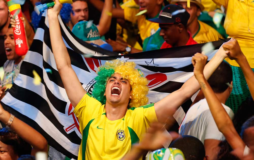 A Brazilian fan celebrates as he watches the 2014 soccer World Cup opening game between Brazil and Croatia at the Fan Fest complex in Recife, Brazil.