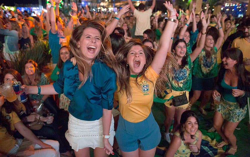 Soccer fans celebrate the second goal scored by Brazil striker Neymar, during a live broadcast at a World Cup viewing party at the Jockey Club, in Rio de Janeiro, Brazil.