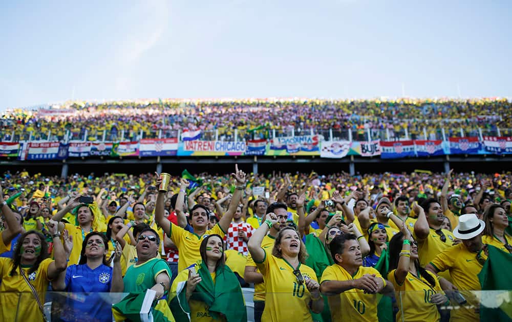 Brazilian soccer fans get ready for the start of the group A World Cup soccer match between Brazil and Croatia, the opening game of the tournament, in the Itaquerao Stadium in Sao Paulo, Brazil.