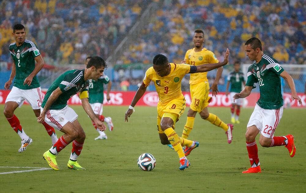 Cameroon's Samuel Eto’o, centre, takes on the Mexican defense during the group A World Cup soccer match between Mexico and Cameroon in the Arena das Dunas in Natal, Brazil.