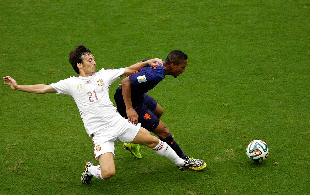 Spain's David Silva, left, fights for the ball with Netherlands' Jonathan de Guzman during the group B World Cup soccer match between Spain and the Netherlands at the Arena Ponte Nova in Salvador, Brazil.