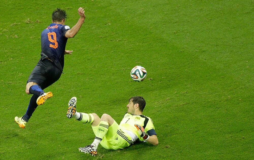 Netherlands' Robin van Persie dribbles Spain's goalkeeper Iker Casillas before scoring during the group B World Cup soccer match between Spain and the Netherlands at the Arena Ponte Nova in Salvador, Brazil.