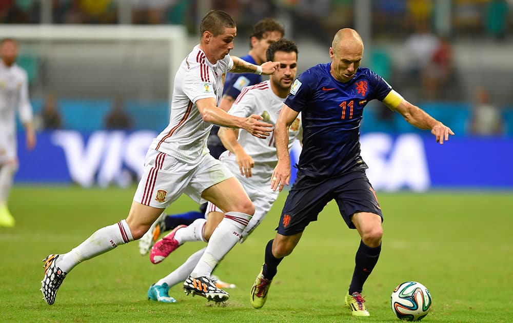 Netherlands' Arjen Robben, right, is challenged by Spain's Fernando Torres during the group B World Cup soccer match between Spain and the Netherlands at the Arena Ponte Nova in Salvador, Brazil