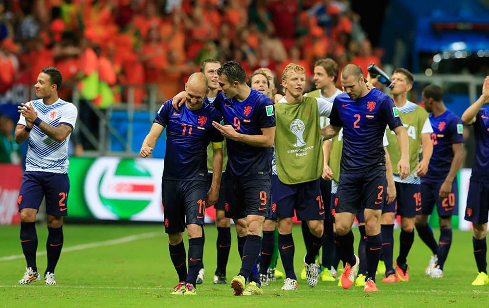 Dutch players celebrate after the group B World Cup soccer match between Spain and the Netherlands at the Arena Ponte Nova in Salvador, Brazil.. The Netherlands won the match 5-1.