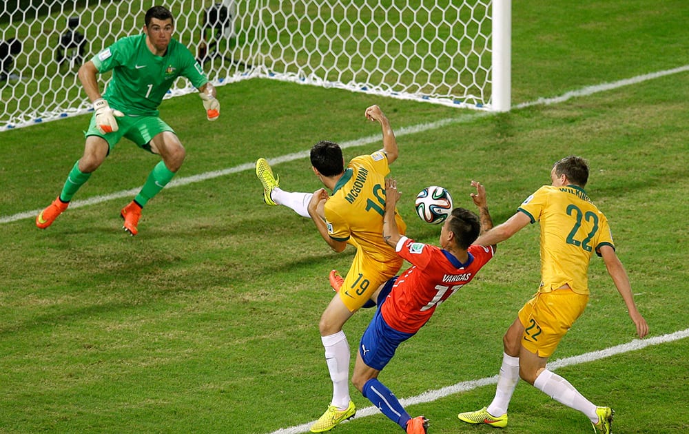 Chile's Eduardo Vargas, second right, fights for the ball with Australia's Ryan McGowan, left, and Australia's Alex Wilkinson during the group B World Cup soccer match between Chile and Australia in the Arena Pantanal in Cuiaba, Brazil.