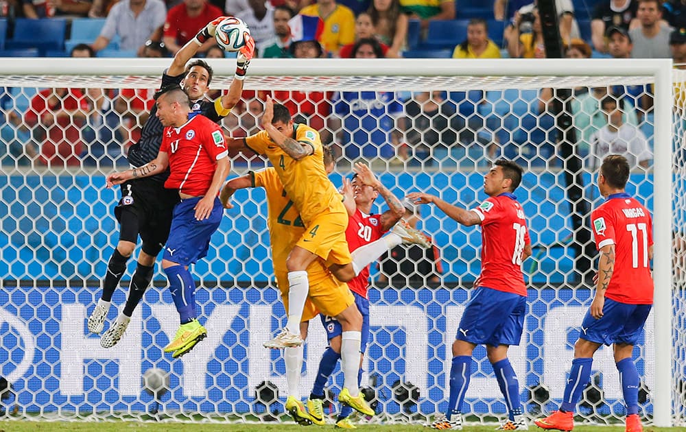 Chile's goalkeeper Claudio Bravo, leaps into the air to claim a cross during the group B World Cup soccer match between Chile and Australia in the Arena Pantanal in Cuiaba, Brazil.