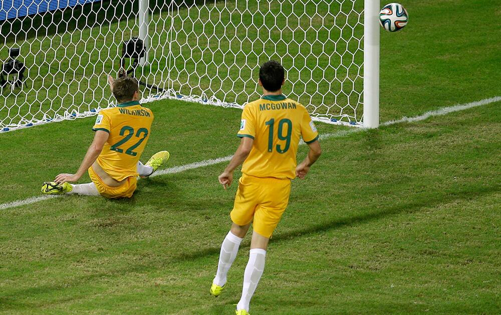 Australia's Alex Wilkinson, left, saves a goal during the group B World Cup soccer match between Chile and Australia in the Arena Pantanal in Cuiaba, Brazil.