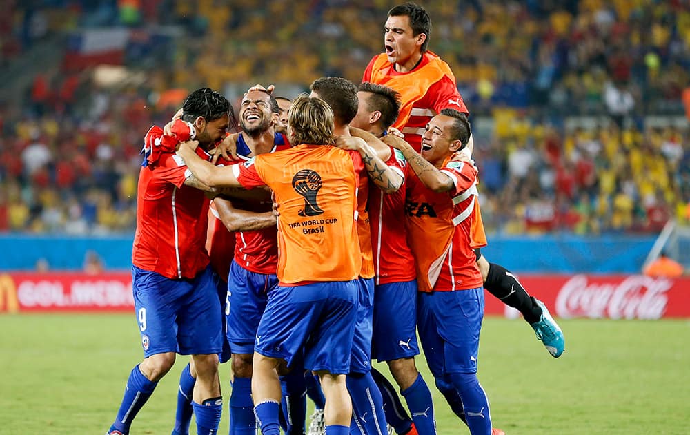 Chile's Jean Beausejour, second from left, celebrates with teammates after scoring his side's third goal during the group B World Cup soccer match between Chile and Australia in the Arena Pantanal in Cuiaba, Brazil.