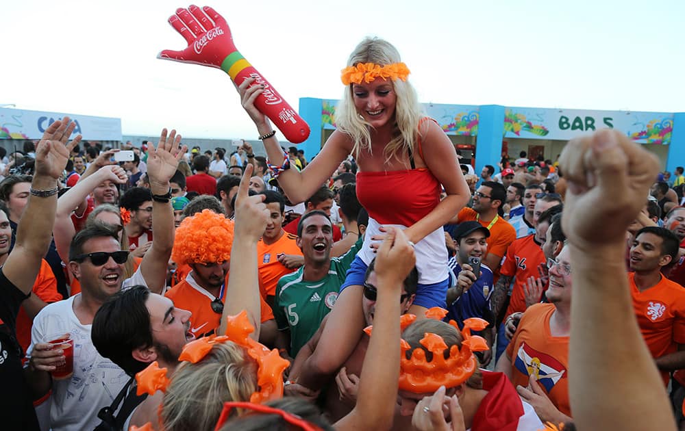 Soccer fans celebrate a goal scored by the Netherlands during a live broadcast of the World Cup match with Spain, inside the FIFA Fan Fest area on Copacabana beach in Rio de Janeiro, Brazil.