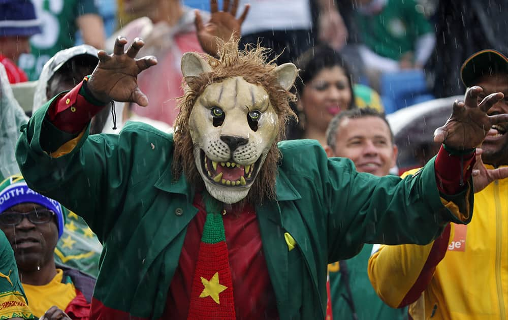 A Cameroon supporter wearing a mask gestures before the start of the group A World Cup soccer match between Mexico and Cameroon in the Arena das Dunas in Natal, Brazil.