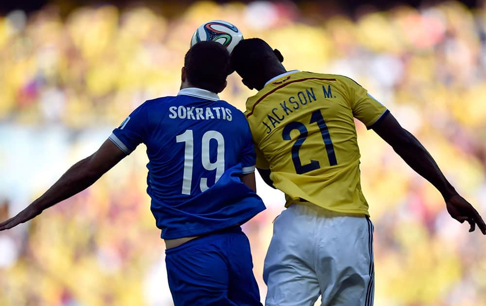 Greece's Sokratis Papastathopoulos, left, heads the ball against Colombia's Jackson Martinez during the group C World Cup soccer match between Colombia and Greece at the Mineirao Stadium in Belo Horizonte, Brazil.