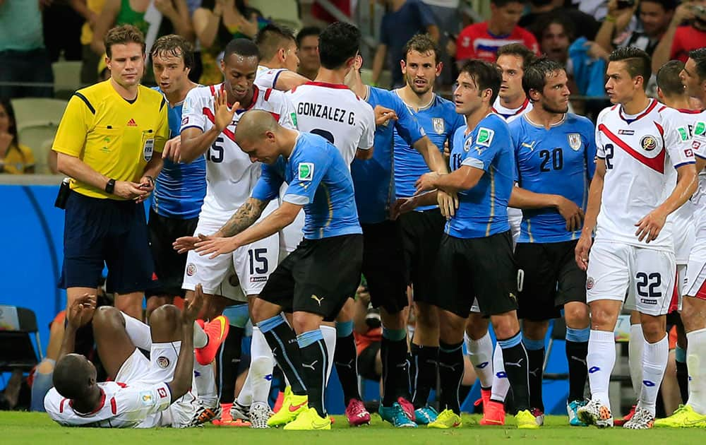 Uruguay's Maxi Pereira reaches out to Costa Rica's Joel Campbell, left, after he fouled him during the group D World Cup soccer match between Uruguay and Costa Rica at the Arena Castelao in Fortaleza, Brazil.