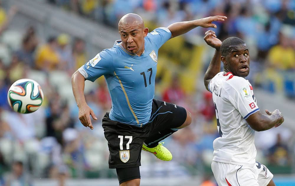 Uruguay's Egidio Arevalo Rios, left, and Costa Rica's Joel Campbell battle for the ball during the group D World Cup soccer match between Uruguay and Costa Rica at the Arena Castelao in Fortaleza, Brazil.