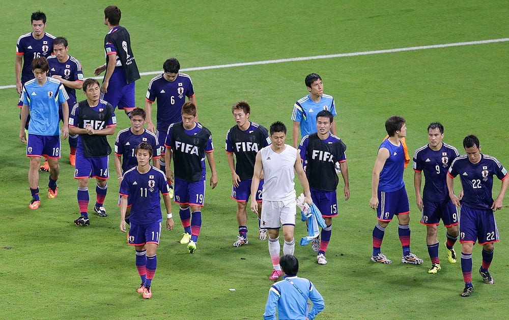 The Japanese team leaves the pitch after the group C World Cup soccer match between Ivory Coast and Japan at the Arena Pernambuco in Recife, Brazil.