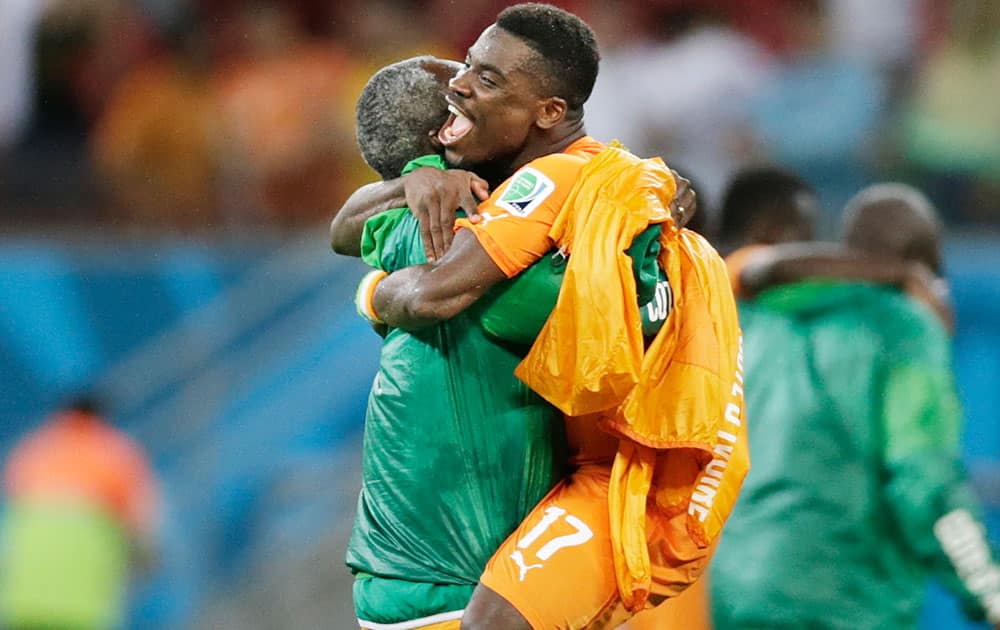 Ivory Coast's Serge Aurier is hugged by a team member after their 2-1 victory over Japan in a group C World Cup soccer match at the Arena Pernambuco in Recife, Brazil.