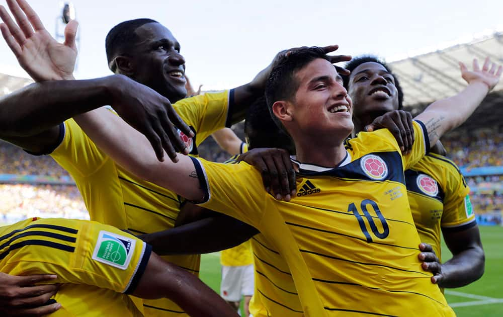 Colombia's James Rodriguez (10) celebrates with his teammates after scoring his side's third goal during the group C World Cup soccer match between Colombia and Greece at the Mineirao Stadium in Belo Horizonte, Brazil.