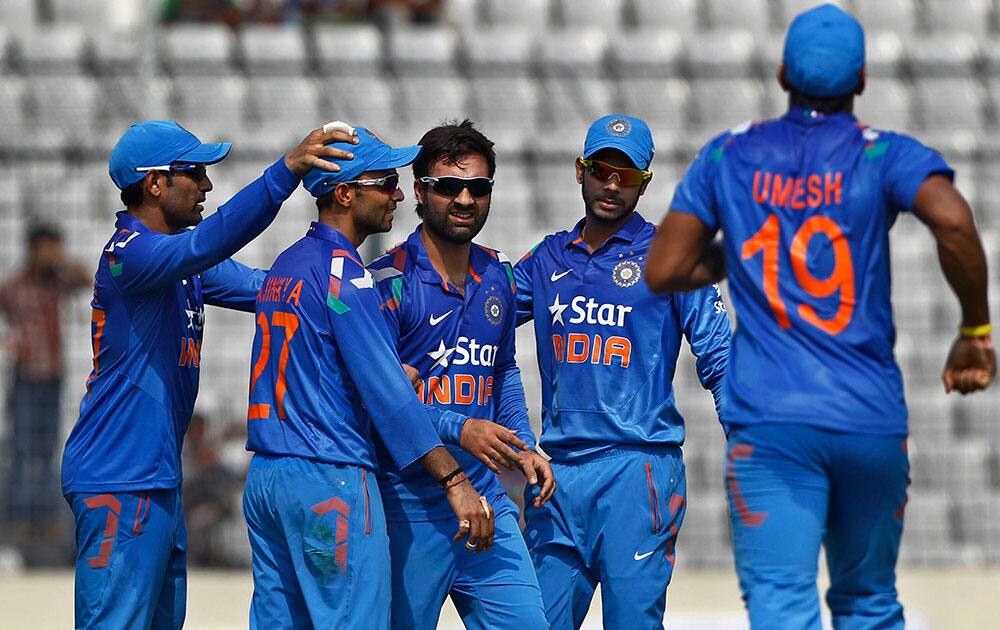 India's Parvez Rasool, center, celebrates with his teammates the wicket of Bangladesh’s captain Mushfiqur Rahim during their first one-day International cricket match in Dhaka.