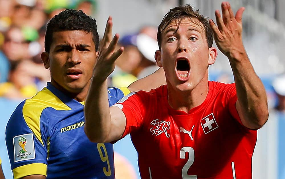 Switzerland's Stephan Lichtsteiner, right, reacts as he stands next to Ecuador's Joao Rojas during the group E World Cup soccer match between Switzerland and Ecuador at the Estadio Nacional in Brasilia, Brazil.