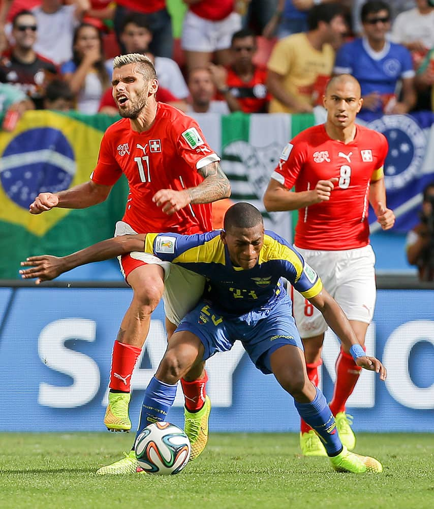 Switzerland's Valon Behrami, left, is fouled by Ecuador's Carlos Gruezo during the group E World Cup soccer match between Switzerland and Ecuador at the Estadio Nacional in Brasilia, Brazil.