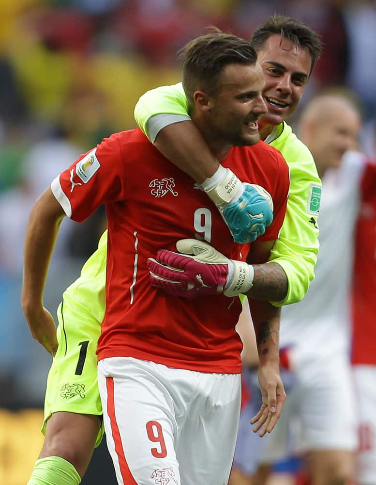 Switzerland's Haris Seferovic, front, and goalkeeper Diego Benaglio celebrate after the group E World Cup soccer match between Switzerland and Ecuador at the Estadio Nacional in Brasilia, Brazil.