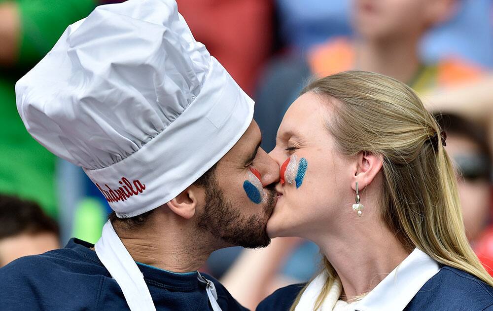 A French couple kiss before the group E World Cup soccer match between France and Honduras at the Estadio Beira-Rio in Porto Alegre, Brazil.