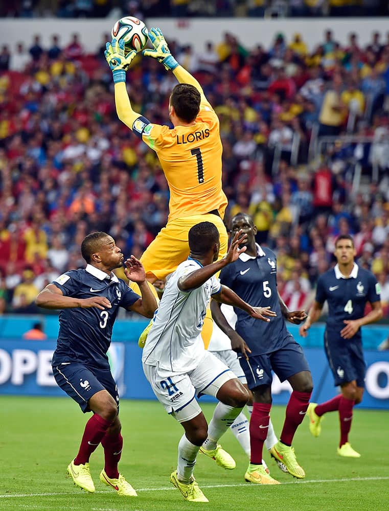 France's goalkeeper Hugo Lloris leaps up to catch the ball over Honduras' Brayan Beckeles (21) during the group E World Cup soccer match between France and Honduras at the Estadio Beira-Rio in Porto Alegre, Brazil.