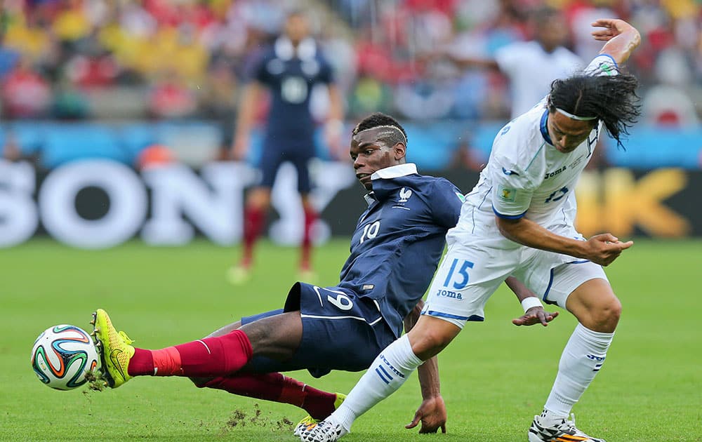 France's Paul Pogba, left, challenges Honduras' Roger Espinoza during the group E World Cup soccer match between France and Honduras at the Estadio Beira-Rio in Porto Alegre, Brazil.