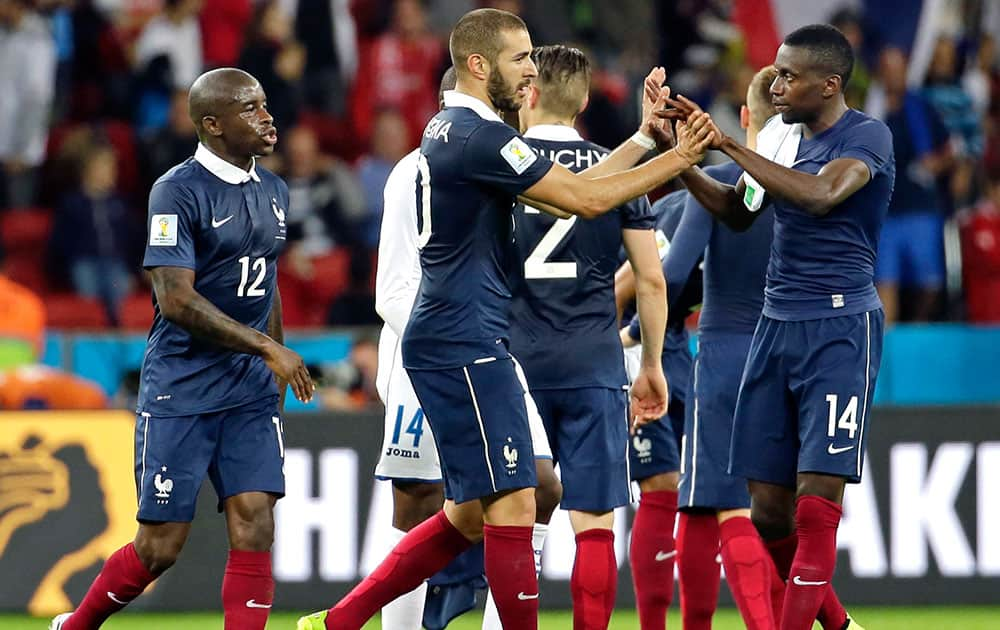 France's Karim Benzema, center, is congratulated by France's Blaise Matuidi (14), Rio Mavubaand (12) and other teammates after their 3-0 victory over Honduras during the group E World Cup soccer match between France and Honduras at the Estadio Beira-Rio in Porto Alegre, Brazil.