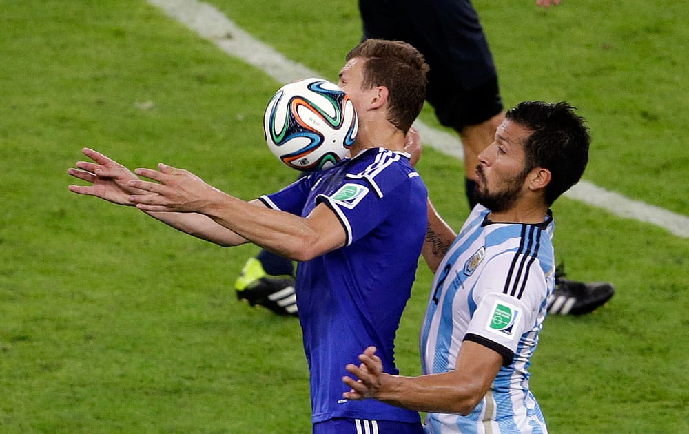 Bosnia's Edin Dzeko, left, and Argentina's Ezequiel Garay challenge for the ball during the group F World Cup soccer match between Argentina and Bosnia at the Maracana Stadium in Rio de Janeiro, Brazil.