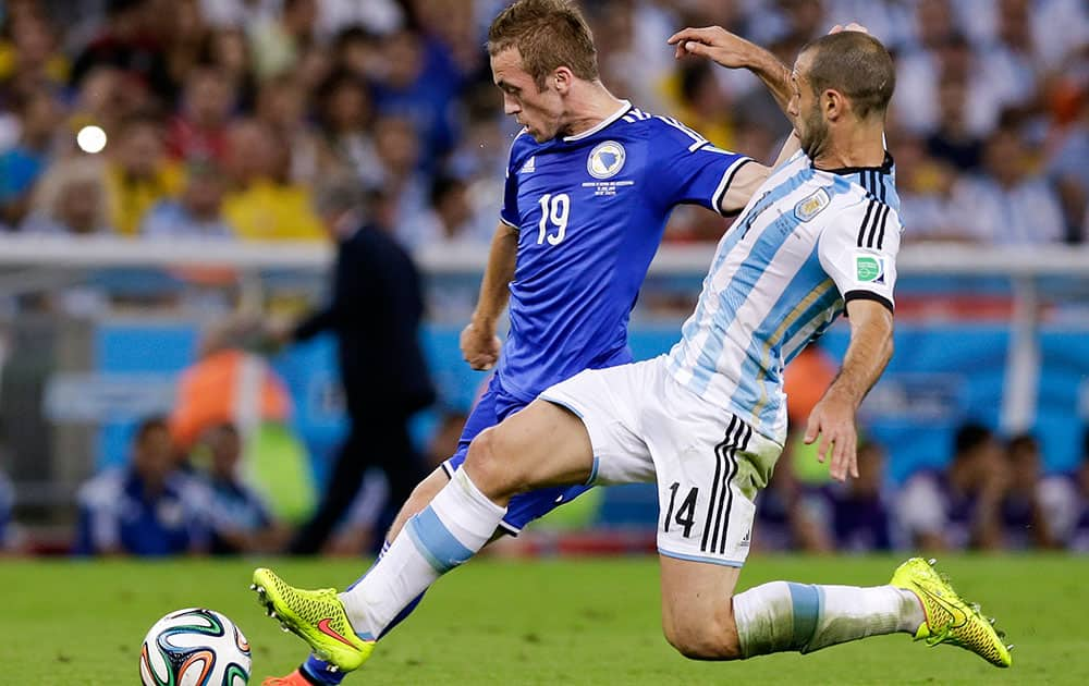 Argentina's Javier Mascherano (14) chases after Bosnia's Edin Visca (19) during a group F World Cup soccer match at the Maracana Stadium in Rio de Janeiro, Brazil.