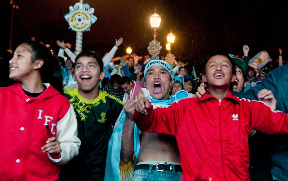 Argentina soccer fans celebrate their team's goal against Bosnia while watching the World Cup soccer game on an outdoor display set up in Buenos Aires, Argentina.