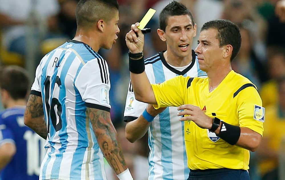 Referee Joel Aguilar from El Salvador gives a yellow card to Argentina's Marcos Rojo, left, during the group F World Cup soccer match between Argentina and Bosnia at the Maracana Stadium in Rio de Janeiro, Brazil.