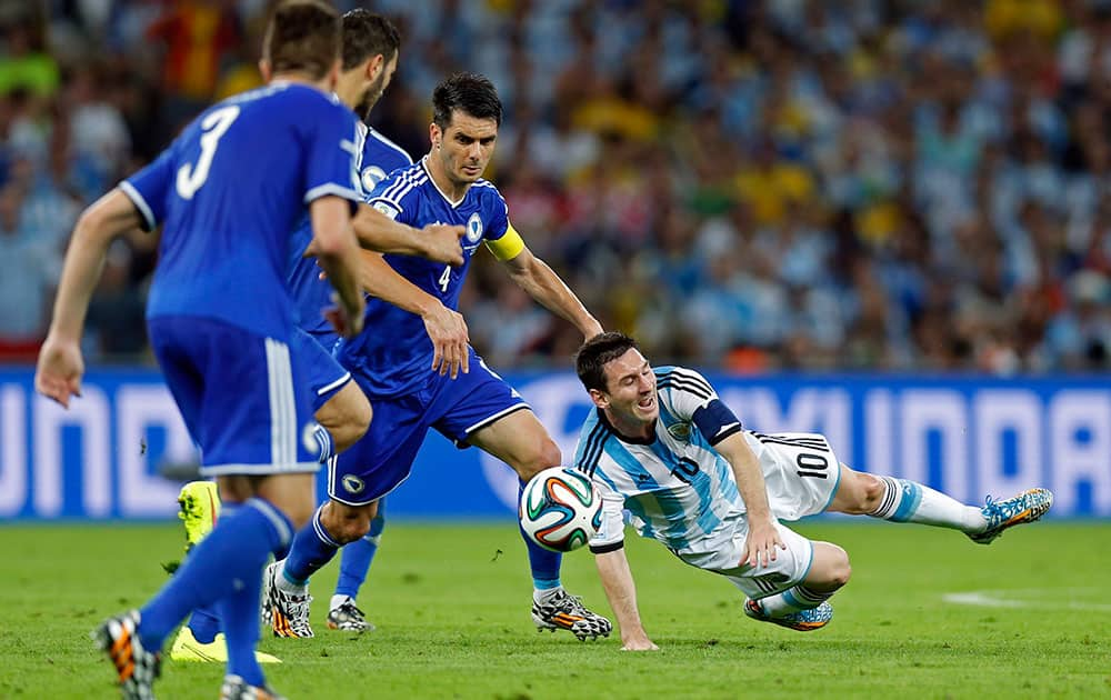 Argentina's Lionel Messi falls to the pitch after being fouled during the group F World Cup soccer match between Argentina and Bosnia at the Maracana Stadium in Rio de Janeiro, Brazil.