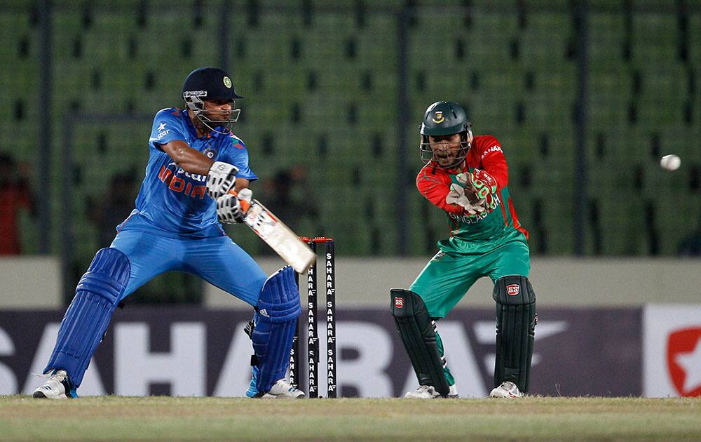 India's captain Suresh Raina, left, plays a shot, as Bangladesh's captain Mushfiqur Rahim watches during their first one-day International cricket match in Dhaka, Bangladesh.