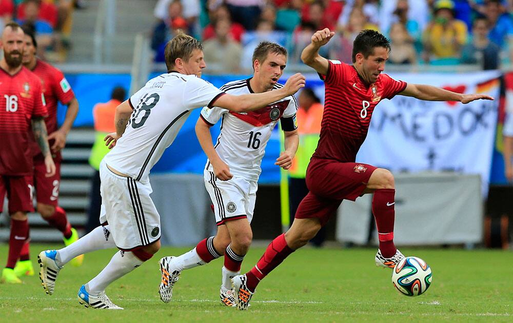 Portugal's Joao Moutinho, right, goes on the attack during the group G World Cup soccer match between Germany and Portugal at the Arena Fonte Nova in Salvador, Brazil.